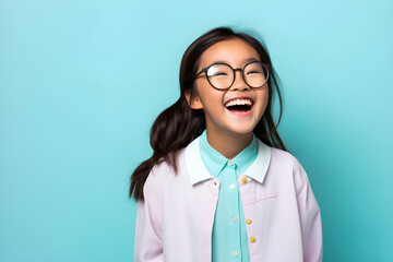 portrait of happy nerdy Asian girl isolated on blue background