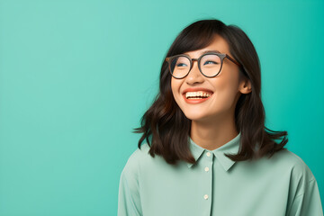portrait of happy nerdy Asian teen girl isolated on blue background - obrazy, fototapety, plakaty