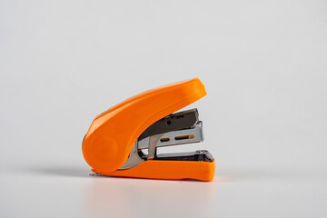 Orange stapler, view side stapler on white background.