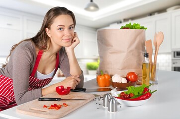 Beautiful young female preparing food at home.