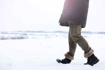 Outdoor portrait of handsome man in coat and scurf. Bearded man in the winter woods.