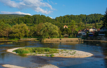 Fototapeta na wymiar The River Una as it passes through Kulen Vakuf village in the Una National Park. Una-Sana Canton, Federation of Bosnia and Herzegovina. Early September