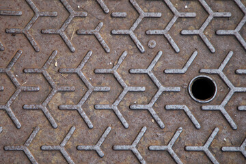 background brown sewer plate cast rusty iron steel on sidewalk of the street