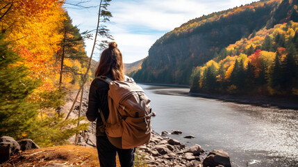 Obraz premium Autumn nature hiker girl walking in national park in Quebec with backpack. Woman tourist going camping in forest. Canada travel hiking tourism at Hautes-Gorges-de-la-Riviere-Malbaie Na. generative ai.