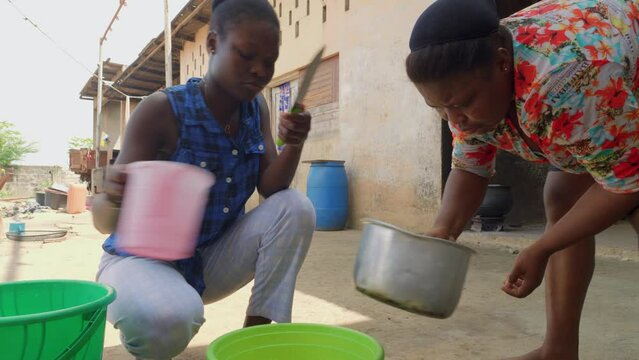 couple of black female African woman preparing traditional west africa food called fufu 