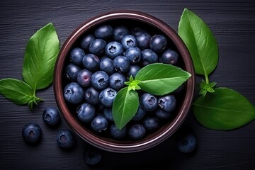 Blueberries with green leaves and bowl, top view. Generative AI
