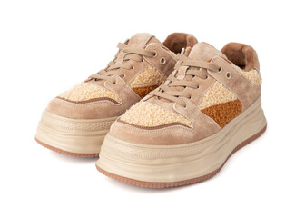Beige plush sneakers on white background. Brown suede sneakers with high soles.