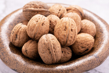 walnuts in shell on ceramic bowl