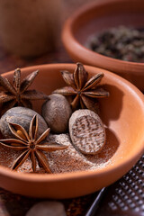Fototapeta na wymiar Spices star anise, nutmeg in isolated ceramic bowl