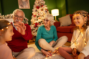Grandparents having fun spending New Year's Eve at home with grandchildren