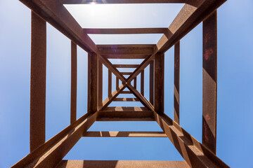 The rusty high-voltage tower, view from the inside. View from bottom to top. Geometric abstraction