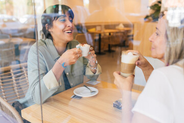 Cheerful women drinking coffee in cafe