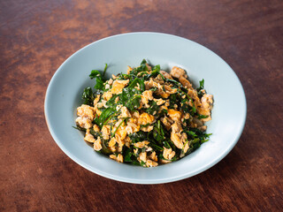 dish of Bai Liang Pad Kai, stir fried Malindjo or Baegu leaves with egg, popular Thai southern dish	