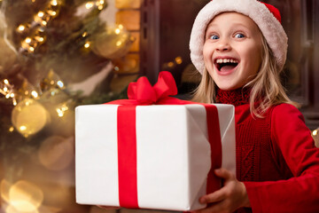 Fototapeta na wymiar Christmas Eve. Child Receiving Christmas Gift Box. Happy Emotions of Kid Christmas Fun 