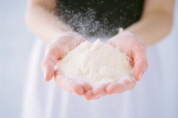 Fototapeta premium Handful of flour. A person holding a pile of white powder in their hands. A heap, a tiny handful, of dry substance in the arms. Closeup of loose powder put in the palms. Face powder