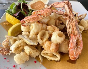 Mixed fried fish on white plate