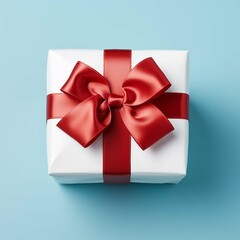 White gift box with red ribbon bow on blue background, top view