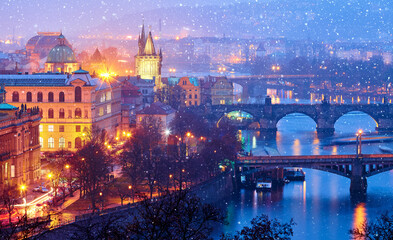 Fototapeta na wymiar Evening over river Vltava near Charles bridge in Prague, Czech republic. Winter snow landscape