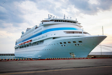 A large white cruise ship is moored in the port. A passenger ship with 11 decks awaits tourists