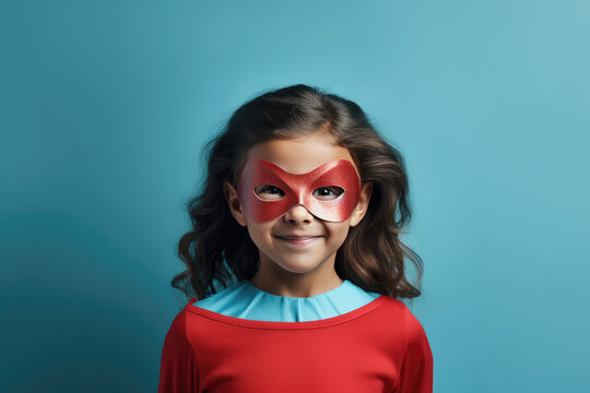 Naklejki a child in a superhero costume isolated on blue background