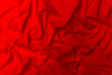 Red silk abstract background or fluid waves or folds of silk. elegant red background