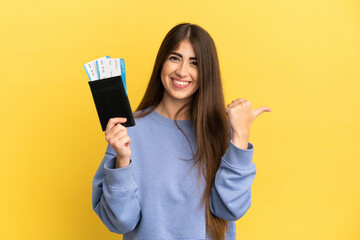 Young caucasian woman holding a passport isolated on yellow background pointing to the side to...