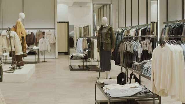 No people shot of luxury designer showroom in black and white colors with stylish clothes hanging on racks