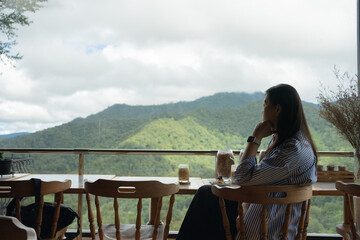 digital nomad concept asian freelancer woman relax and outdoor work at mountain view of coffeeshop