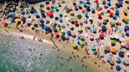 Drone Aerial view beach in Italian town Tropea full of colorful umbrellas and people smimming and sunbathing