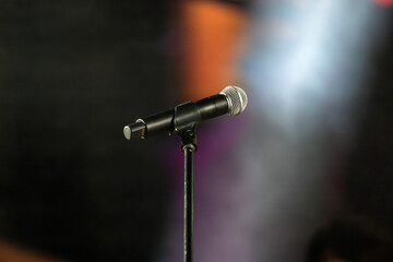Obraz premium Isolated Microphone with stand on a concert stage with blurred stage lighting background