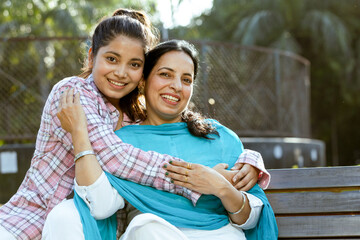 Portrait of happy indian daughter hugging her mother and kissing her, Mother hood concept ,Mother and daughter Friends Concept