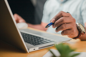 Business accounting concept, businessman using calculator with laptop computer Ready to write a summary of the organization's annual income.
