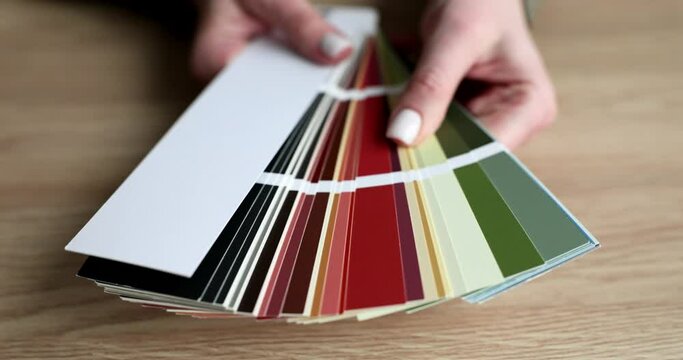 Hands of designer opening fan with color swatches in studio closeup 4k movie slow motion. Design color matching service concept