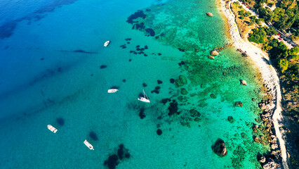 Aerial view of coastal colorful landscape: Turquoise transparent sea water, green trees and rocks