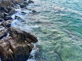 Blue sea and rock. Beautiful sea ​​coast. Coast of the island. Blue sea in winter. Waves crashing on rocks. Seascape on vacation. Blue ocean, white foam and waves. Seaview during travel.