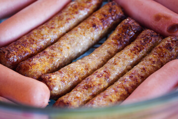 Fried sausages and sausages in transparent glass dishes