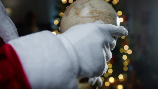 Santa calculating his road on a World map globe 