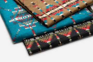 Warm rugs, stoles are stacked in  stack of several rows. Accessories for cold weather from natural material. 