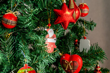 Christmas decorations. Christmas tree with various red Christmas decorations: balls, hearts, icicles, stars