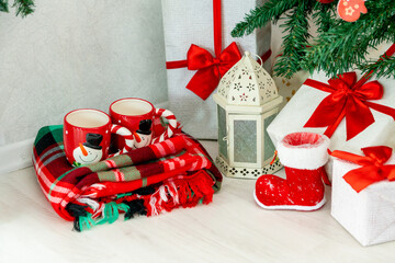 Christmas decorations. Red mugs under the Christmas tree