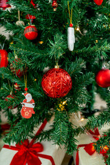 Christmas decorations. Christmas tree with various red Christmas decorations: balls, hearts, icicles, stars