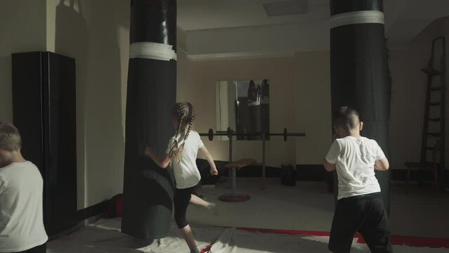 Kids and adult boxers do exercises in sports club