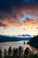 Lake Vyrnwy, located in mid Wales, an area of outstanding natural beauty, at sunset. The orange sky is reflected in the calm water of the lake