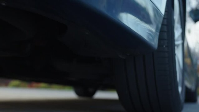 Car starts moving, rear view. Rear wheel of car that begin to move. Vehicle tire, close up