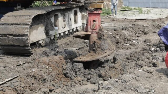 Rotary drilling rig machine auger gets into hole to dig deeper on deep foundation