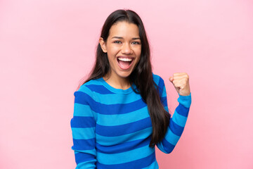 Young Colombian woman isolated on pink background celebrating a victory