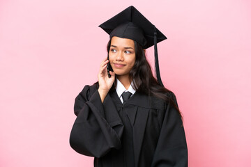 Young university Colombian woman graduate isolated on pink background keeping a conversation with...