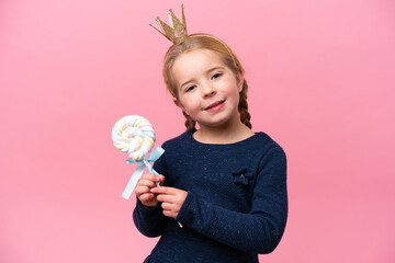Little caucasian girl holding a lollipop isolated on pink background