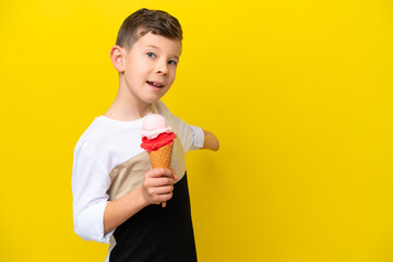 Little caucasian boy with a cornet ice cream isolated on yellow background extending hands to the side for inviting to come © luismolinero