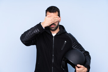 Man with a motorcycle helmet over isolated background covering eyes by hands. Do not want to see...